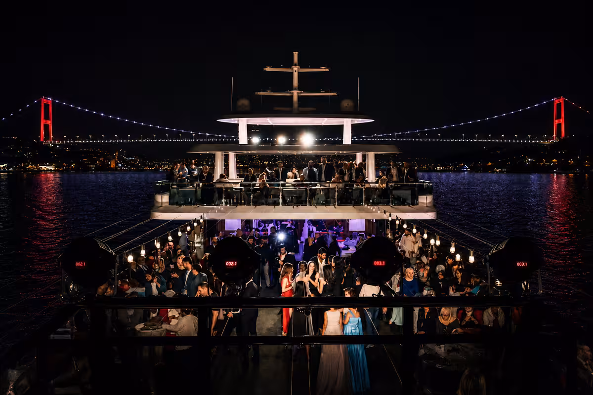 Boğaz Köprüsü ışıkları arka planda teknede gece düğün kutlaması