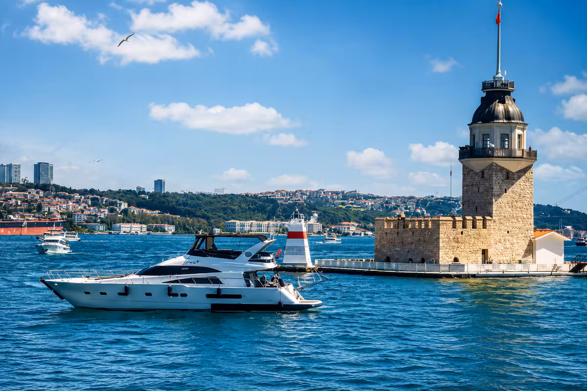 Kız Kulesi önünde teknede mezuniyet partisi, İstanbul Boğazı gün batımı manzarası